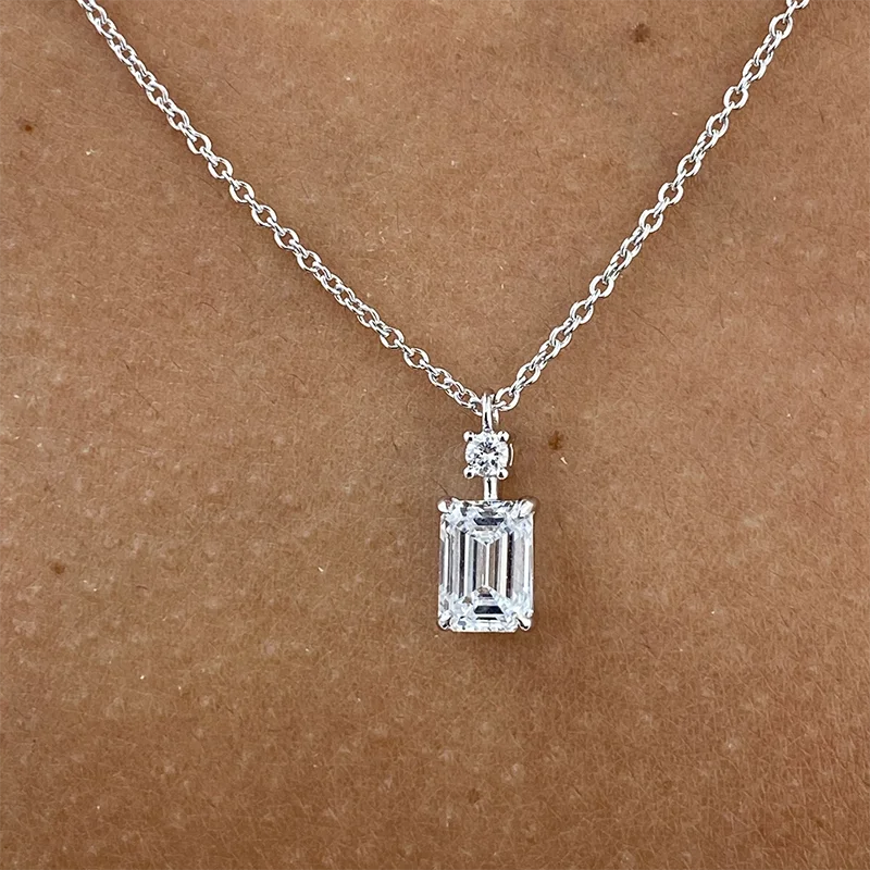 Emerald-cut diamond pendant with round diamond accents