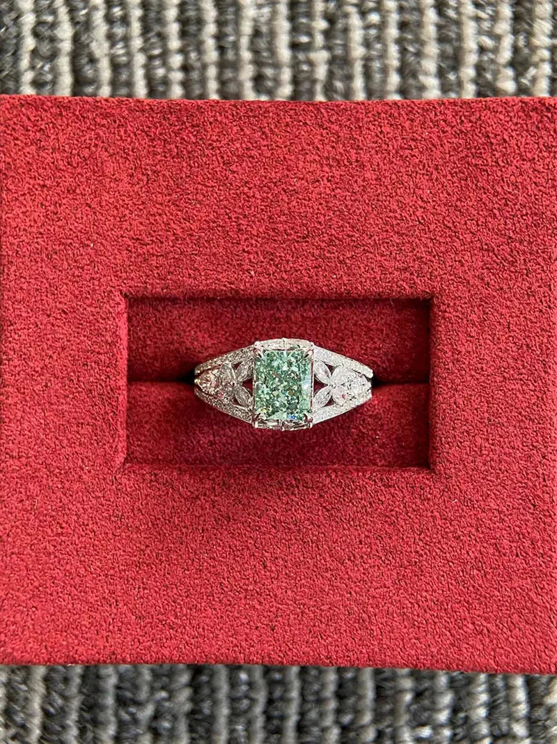 Gold ring with green radiant diamond and pear accents