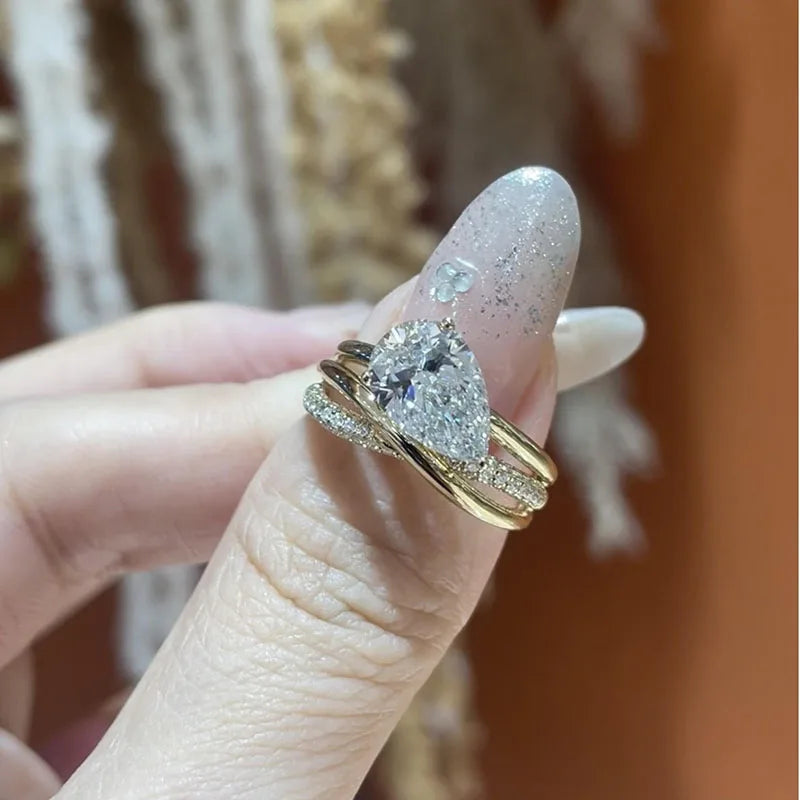 Gold crossover band with pear-shaped diamond