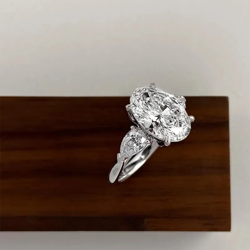 Oval diamond engagement ring with pear-shaped side diamonds