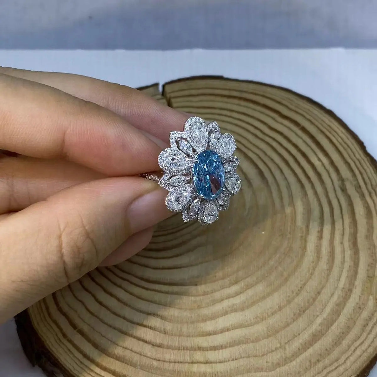 Flower-inspired ring with blue oval diamond