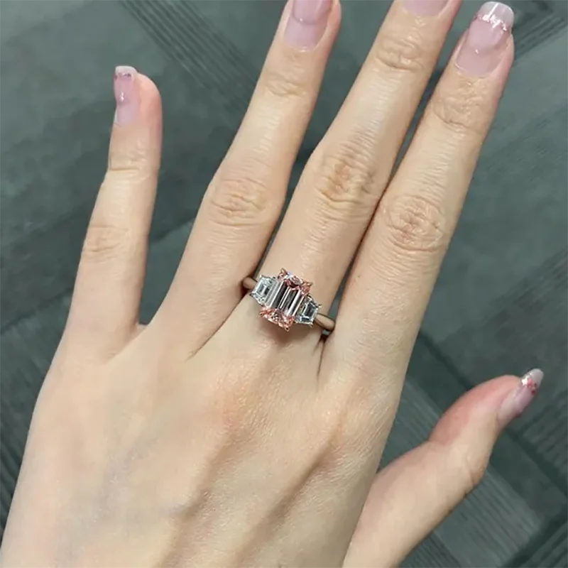 Three-stone ring with pink emerald-cut center diamond