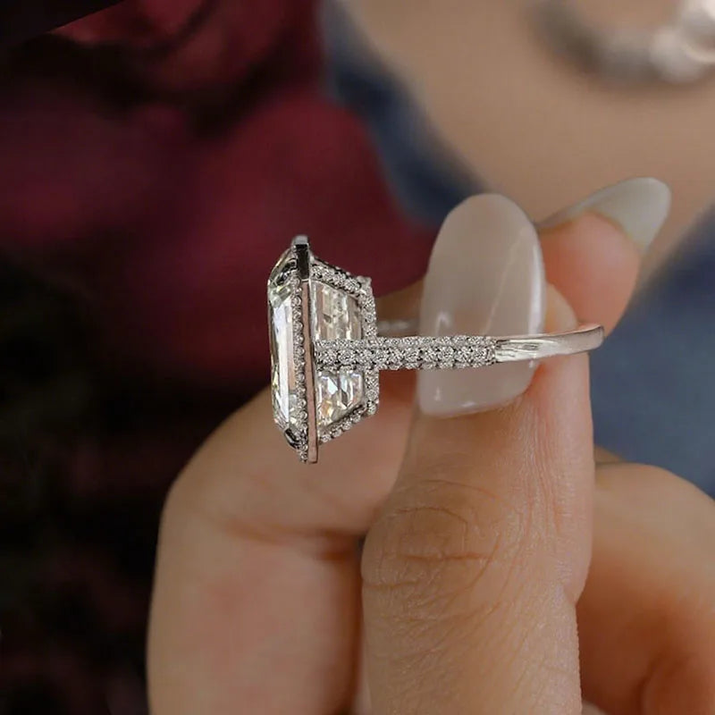 Gold emerald-cut diamond engagement ring with halo