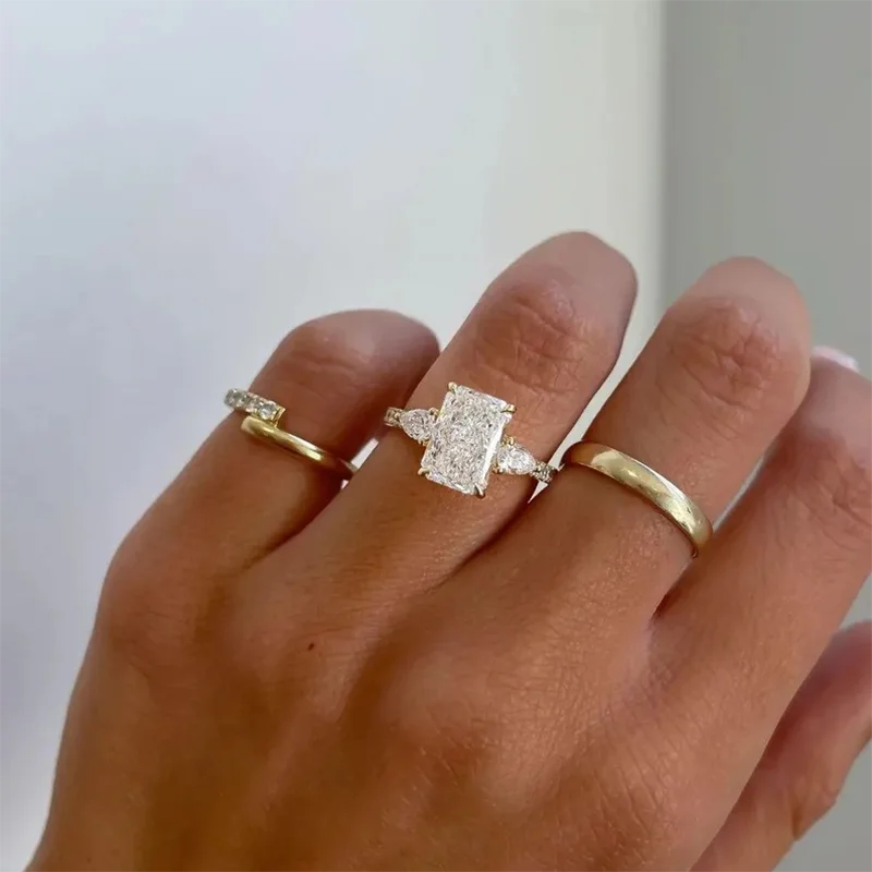 Radiant diamond engagement ring with two side diamonds