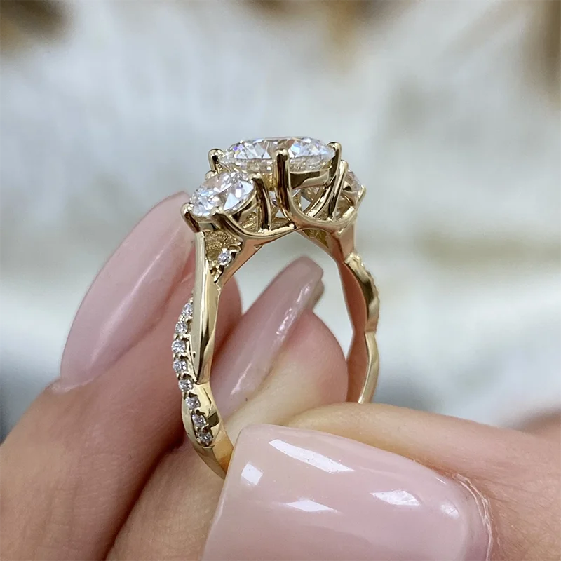 Round diamond engagement ring with two side diamonds and twist shank