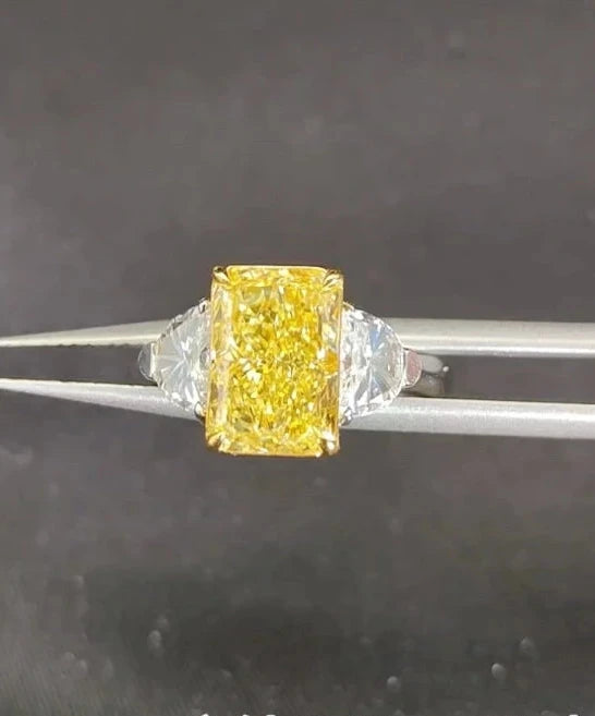 Gold engagement ring with yellow center diamond