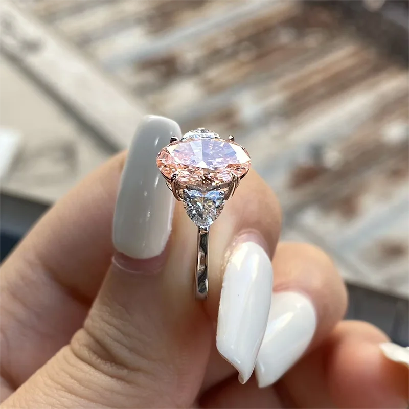 Three-stone pink oval diamond ring with heart-cut accents