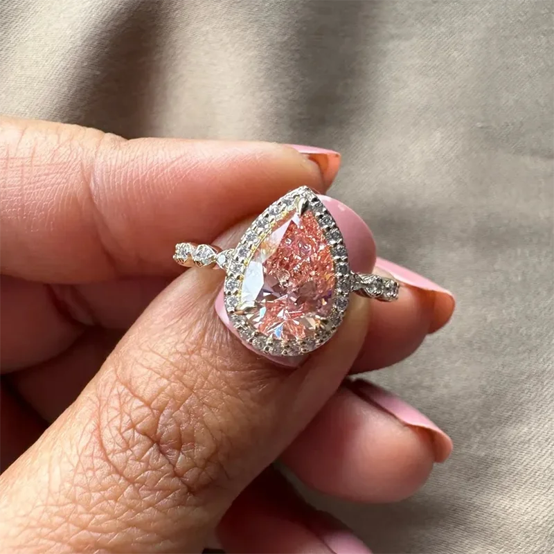 Lab-grown pink diamond ring with pear-cut center and halo