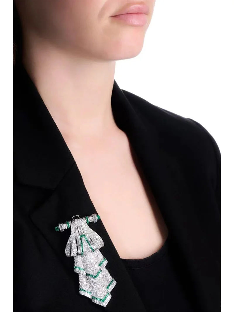 Round and emerald-cut diamond brooch design