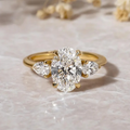 Three-stone lab-grown diamond ring with oval center and pear-shaped side stones