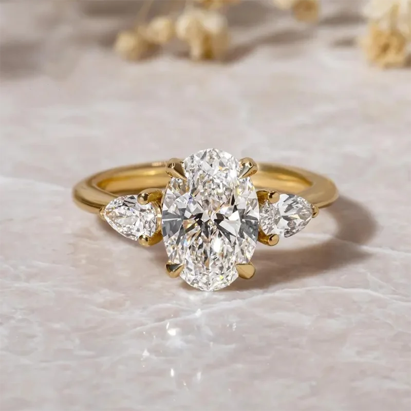 Three-stone lab-grown diamond ring with oval center and pear-shaped side stones