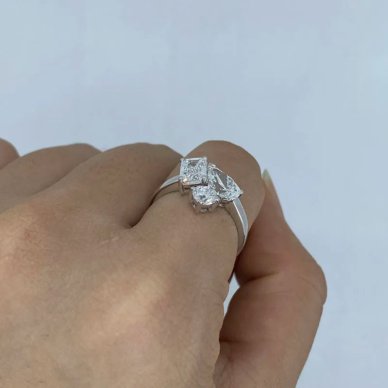 Three-shape emerald pear and round diamond ring